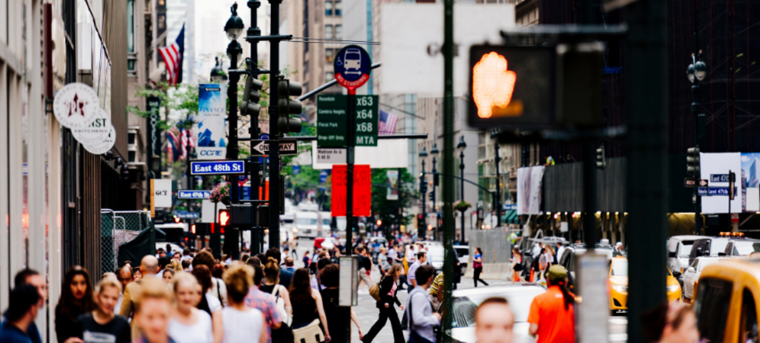 A photo of many pedestrians and cars on a busy roadway