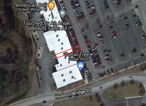 Satellite image of a building that contains multiple businesses. There is a red outline over only part of the building indicating the polygon extent for that specifc business.